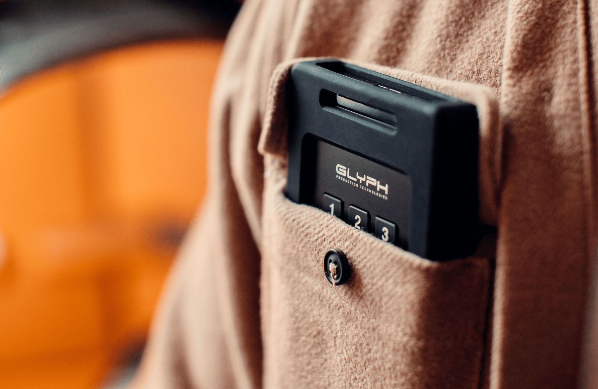 close up of a glyph secure drive in the front pocket of a brown shirt