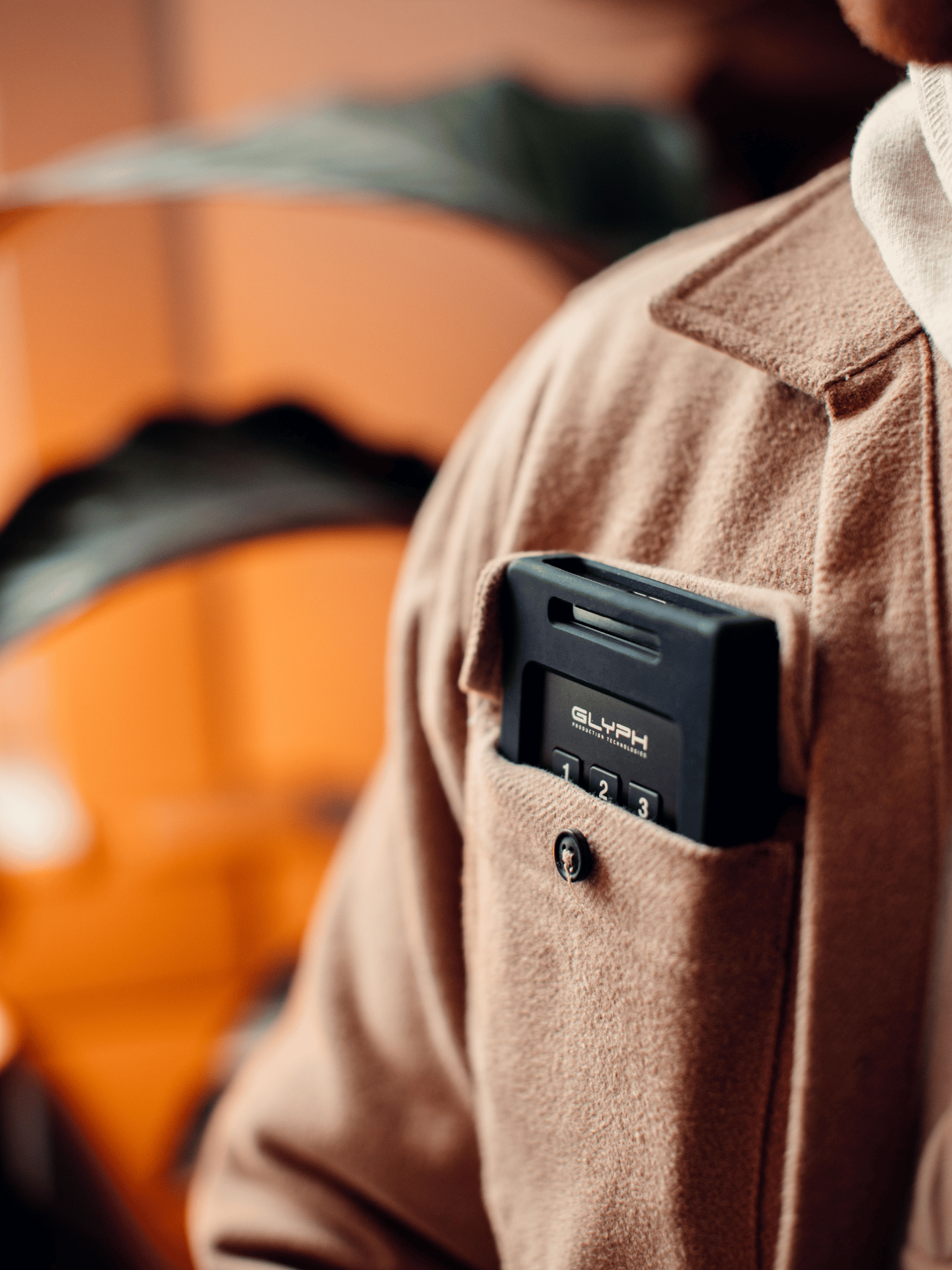 close up of a glyph secure drive in the front pocket of a brown shirt