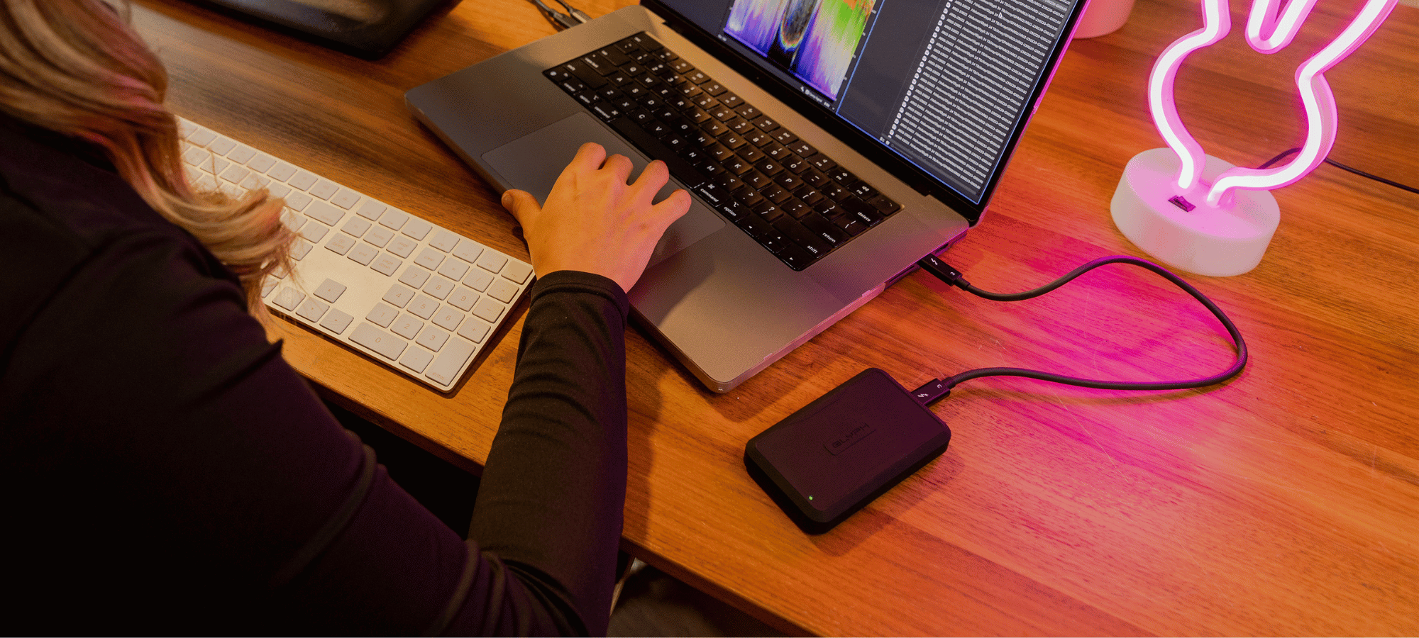 content creator working at her desk on her computer with a glyph drive 